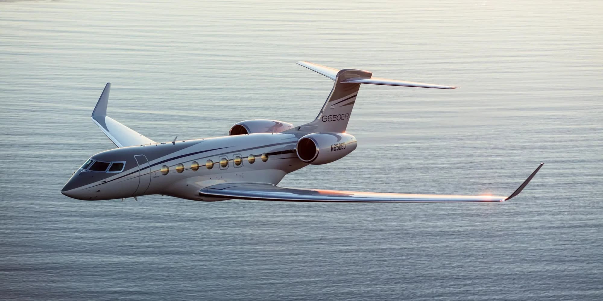 Business jet in flight over the sea in evening light
