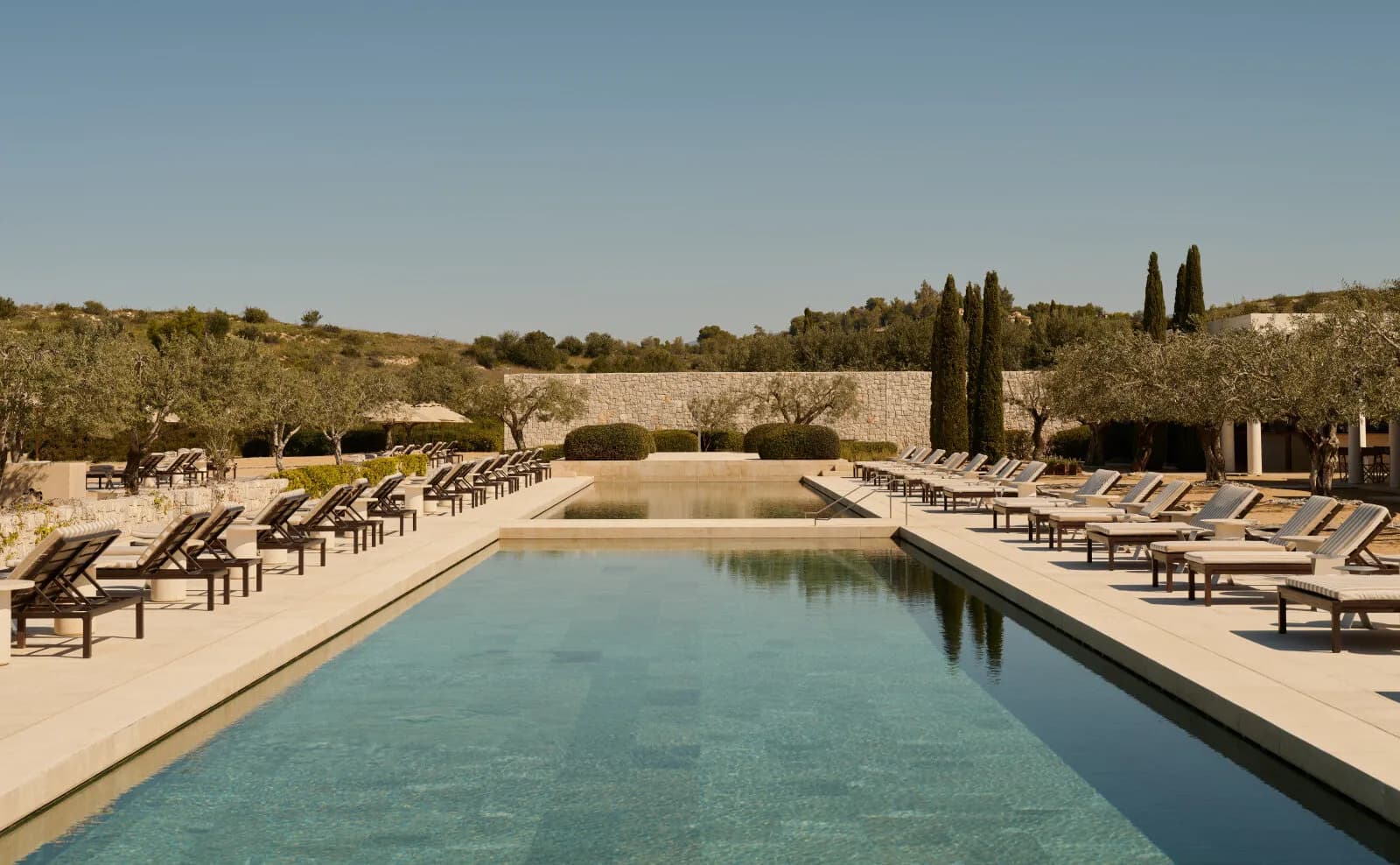 Großer Pool des Amanzoe Resorts über den Olivenhainen