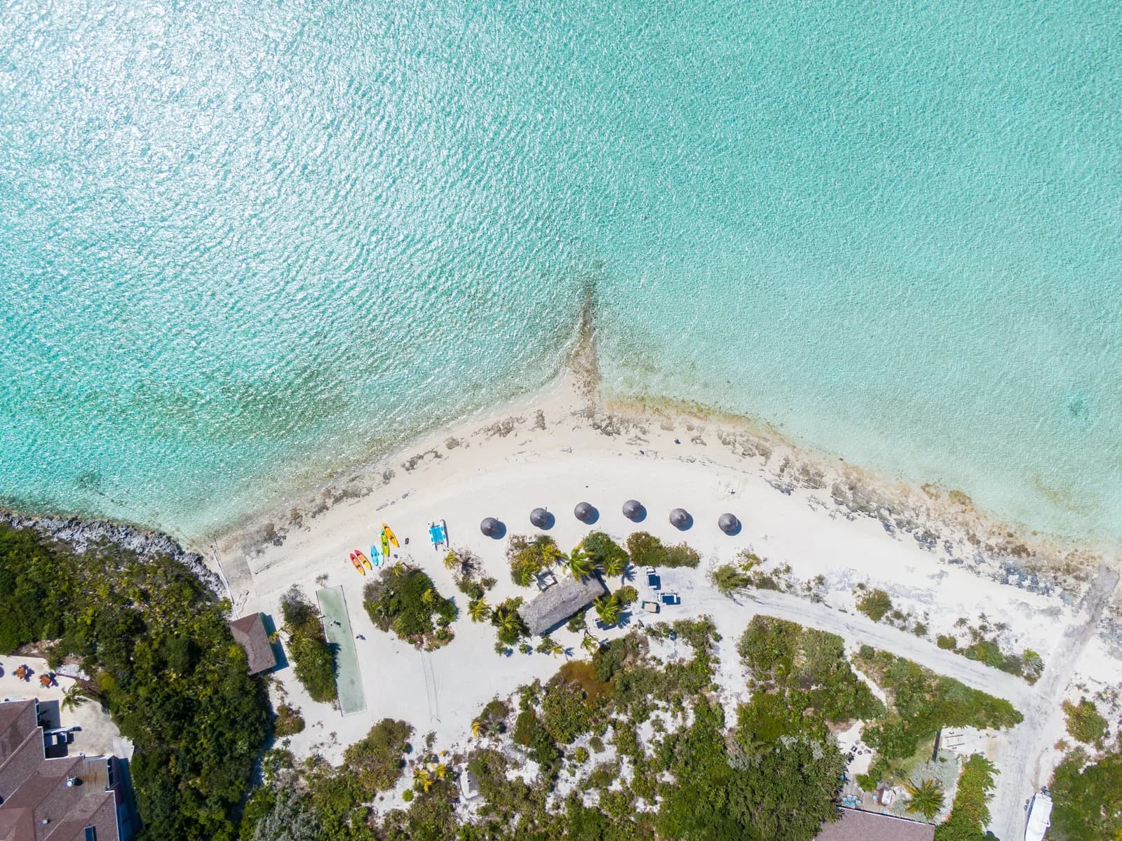 Der Inselstrand mit Sonnenschirmen und Kajaks aus der Luft