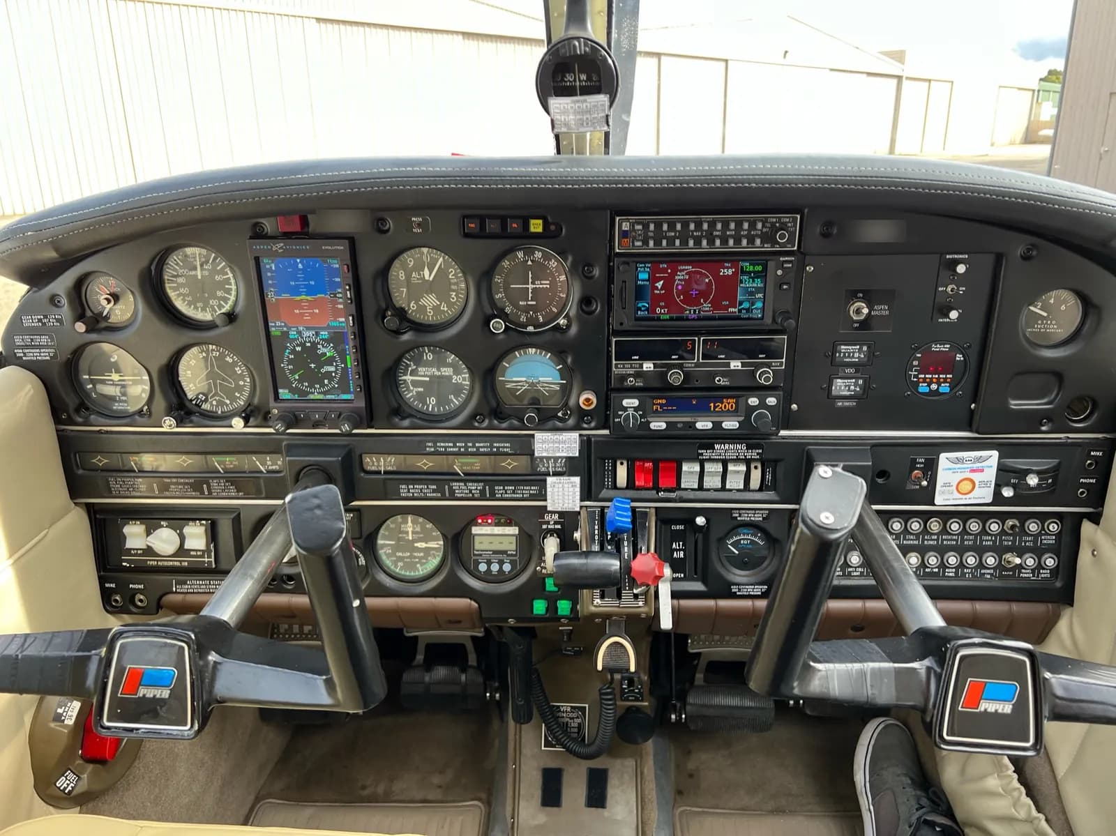 Cockpit of a Piper PA-28 with glass display and round gauges