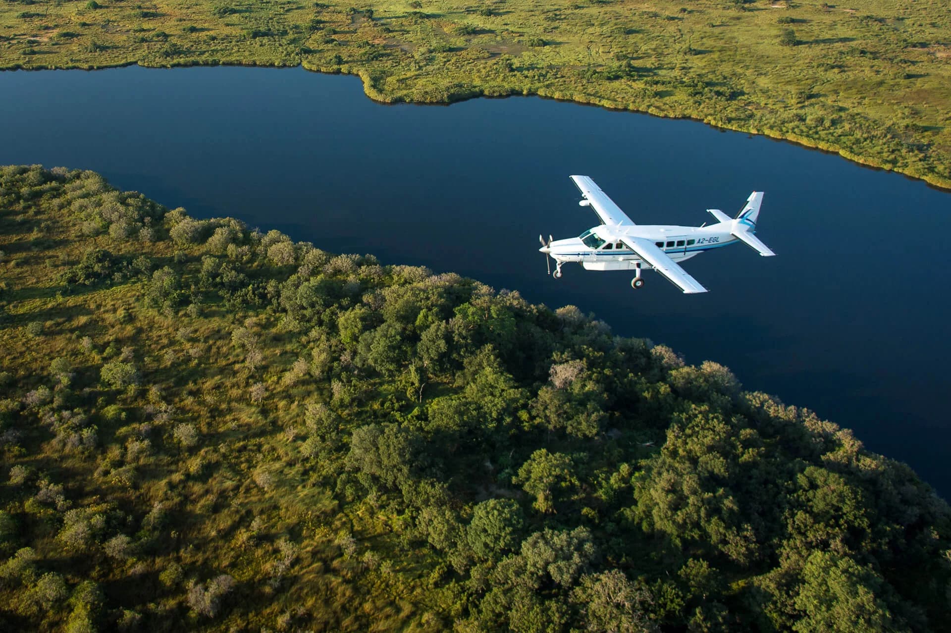 Cessna 208 von Wilderness Air über den Wasserarmen des Okavango-Deltas