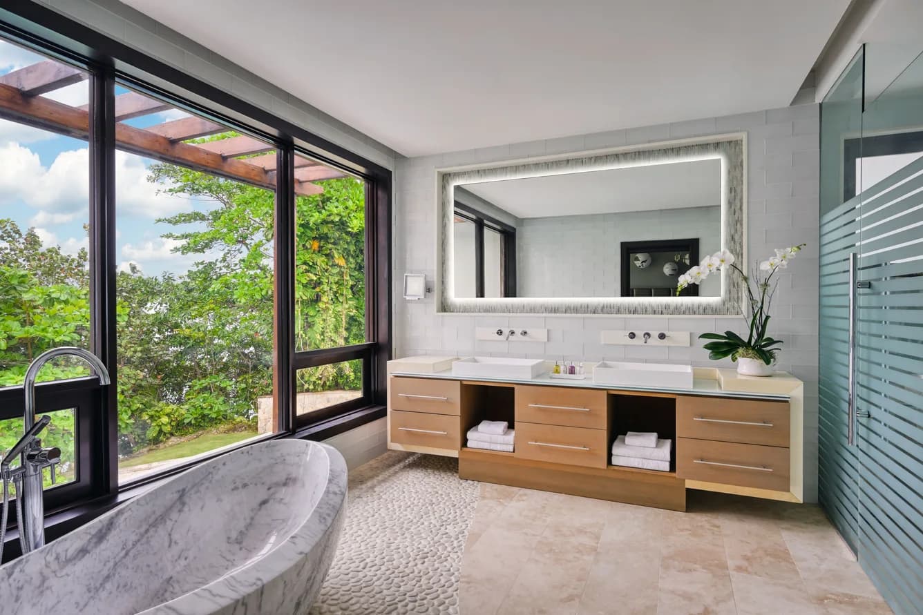 Badezimmer mit Wanne und Blick ins Grün